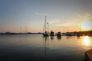 hermosa puesta de sol en la orilla de un puerto de yates foto