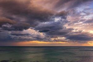 puesta de sol emocionante. hermosas nubes de colores sobre el mar. foto