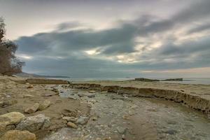 beach by a small river flowing into the sea photo