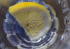 a slice of lemon dipped in sparkling water. close up photo