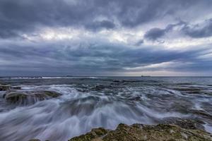 Stunning long exposure cloudy sunset seascape. photo