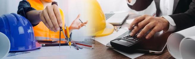 Two colleagues discussing data working and tablet, laptop with on on architectural project at construction site at desk in office photo