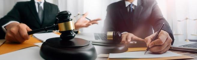 Justice and law concept.Male judge in a courtroom with the gavel, working with, computer and docking keyboard, eyeglasses, on table in morning light photo