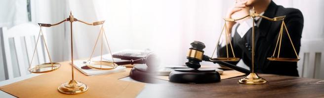 Justice and law concept.Male judge in a courtroom with the gavel, working with, computer and docking keyboard, eyeglasses, on table in morning light photo