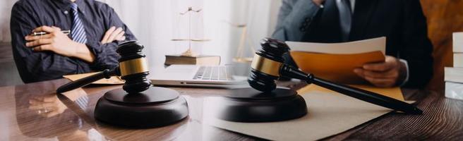 Business and lawyers discussing contract papers with brass scale on desk in office. Law, legal services, advice, justice and law concept picture with film grain effect photo