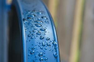 gotas de agua abstractas y con fondo borroso brillan sobre una superficie metálica de una silla foto