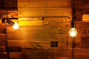 moderno apartamento de diseño interior de estilo clásico oscuro con lámparas retro colgando fondo de bombillas. tablones de madera con lámparas. habitación interior decorada con luces doradas. cartel de maqueta de espacio de copia. foto