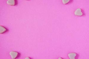 valentine candy hearts shape on pink background photo