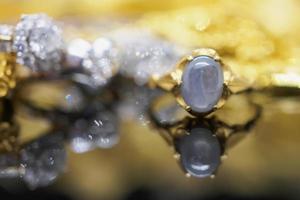 Vintage gold Jewelry blue sapphire rings with reflection on black background photo