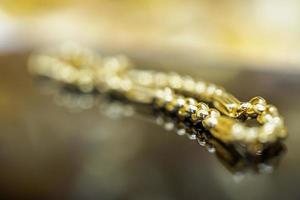 pulsera de joyería de oro de lujo con reflejo en el fondo negro foto