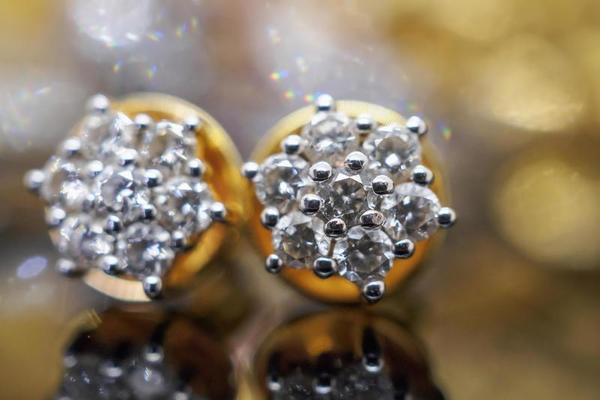 Luxury gold Jewelry diamond earrings with reflection on black background