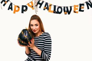 mujer joven con calabaza negra en la decoración de halloween foto