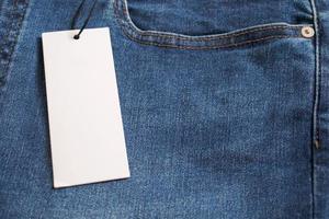 Blue jeans with blank white price label tag photo