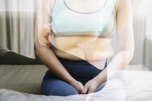 Beautiful fat woman with tape measure She uses her hand to squeeze the excess fat that is isolated on a white background. She wants to lose weight, the concept of surgery and break down fat under the photo