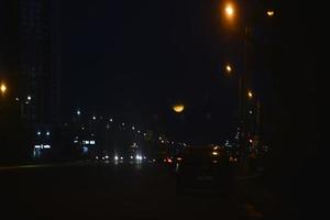 Multicolored reflections of lanterns on the evening road in the evening. Bluer and bokeh from the evening city. photo