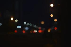 reflejos multicolores de faroles en el camino de la noche por la noche. más azul y bokeh de la ciudad de la tarde. foto
