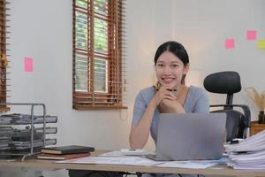 Portrait of Young woman using laptop computer at the office, Student girl working at home. Work or study from home, Asian woman freelance, business, lifestyle concept photo