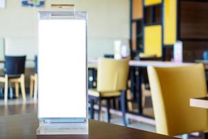 maqueta de marco de menú blanco en blanco en la mesa del restaurante cafetería foto