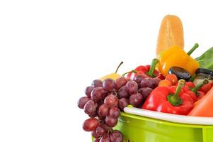 Fresh fruits and vegetables grocery product in green shopping basket isolated on white background photo