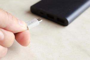 a man holds a charging cable for charging a powerbank photo