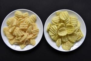 deliciosos chips de maíz con pimienta en un plato blanco. aperitivo de cerveza en un plato sobre un fondo negro. foto