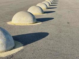 Fencing on the asphalt road in the form of large hemispheres. photo