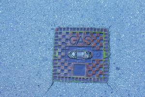 Manhole cover of the gas pipeline system. A massive metal hatch for access to city communications in the pavement. photo