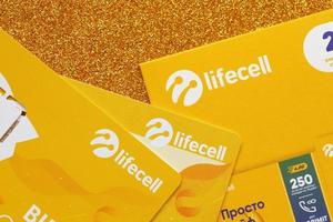 TERNOPIL, UKRAINE - JULY 5, 2022 Lifecell new sim card with free contract on yellow background. Lifecell is ukrainian mobile telephone network operator and provider of wireless connection photo