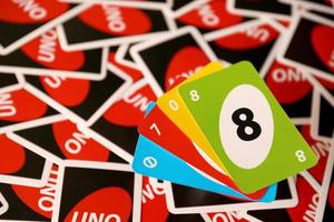 TERNOPIL, UKRAINE - MAY 15, 2022 Many colorful UNO game cards. UNO is an American shedding-type card game that is played with a specially printed deck photo