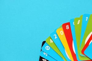 TERNOPIL, UKRAINE - MAY 15, 2022 Many colorful UNO game cards on blue background. UNO is an American shedding-type card game that is played with a specially printed deck photo