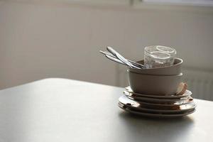 Stack of dirty dishes with food leftovers on the table after meal. Banquet ending concept. Unwashed dishes photo