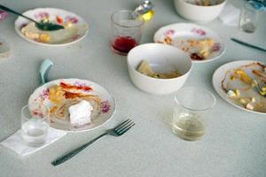 Empty dirty plates with spoons and forks on the table after meal. Banquet ending concept. Unwashed dishes photo