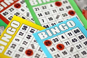 Many colorful bingo boards or playing cards for winning chips. Classic US or canadian five to five bingo cards on bright background photo