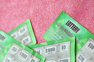 Close up view of green lottery scratch cards. Many used fake instant lottery tickets with gambling results. Gambling addiction photo