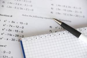 escritura a mano de ecuaciones cuadráticas matemáticas en exámenes, prácticas, cuestionarios o pruebas en clase de matemáticas. resolver el concepto de ecuaciones exponenciales. foto