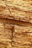 fondo de piedra de roca natural gruesa y clara. superficie frontal rugosa del acantilado minero. gran pila de piedra caliza como telón de fondo. textura de bloque de granito dañado grunge pesado foto