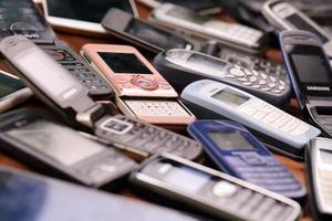 KHARKIV, UKRAINE - DECEMBER 16, 2021 Some old used outdated mobile phones from 90s-2000s period. Recycling electronics in the market photo