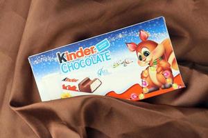 KHARKIV, UKRAINE - DECEMBER 16, 2021 Kinder Chocolate is a children dessert snack made by Italian confectionery brand Ferrero S.p.A. photo