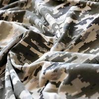 tela con textura de camuflaje pixelado militar ucraniano. tela con patrón de camuflaje en formas de píxeles grises, marrones y verdes. uniforme oficial de los soldados ucranianos foto