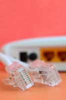 Internet router and Internet cable plugs lie on a bright orange background. Items required for Internet connection photo