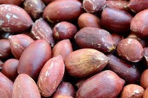 Peanut. A lot of small yellow nuts with brown peel. Background texture photo