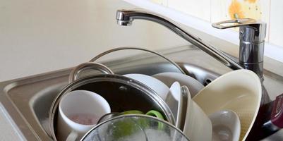 Dirty dishes and unwashed kitchen appliances filled the kitchen sink photo