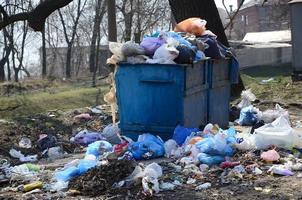 The garbage can is packed with garbage and waste. Untimely removal of garbage in populated areas photo