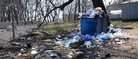 The garbage can is packed with garbage and waste. Untimely removal of garbage in populated areas photo