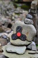 A wooden spinner lies on strange stone structures in the forest photo