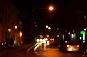 Blurred night scene of traffic on the roadway. Defocused image of cars traveling with luminous headlights. Bokeh Art photo