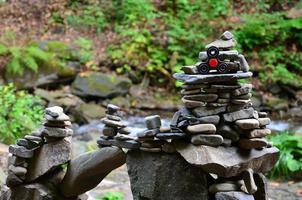 A wooden spinner lies on strange stone structures in the forest photo