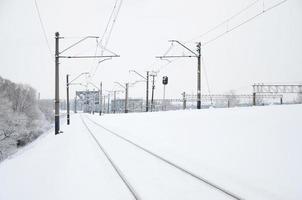 paisaje ferroviario de invierno, vías férreas en el país industrial cubierto de nieve foto