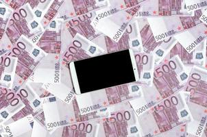 billetes morados de 500 euros y un smartphone con pantalla negra. copie el espacio el concepto de banca en línea, administración de dinero y compras con tecnología moderna foto