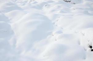 Fragment of the road, covered with a thick layer of snow. The texture of the glistening snow cover photo